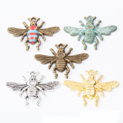 Group view of the bee charm showing the available finishes and front details