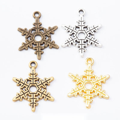 Assorted snowflake charms arranged together on a white background