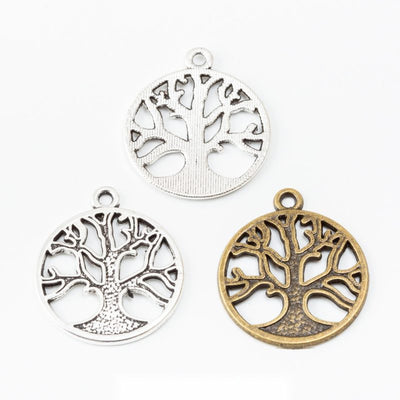 Assorted round tree of life charms arranged together on a white background