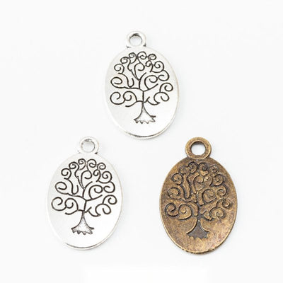 Grouped front views of the oval tree of life cutout charm in two antique finishes