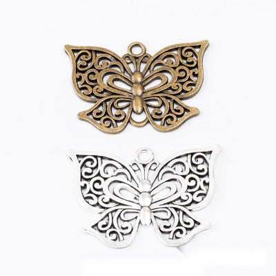 Filigree Butterfly Charm Pendant finish comparison showing layered wings filled with scrolling openwork