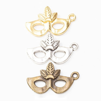 Grouped front views of the leaf masquerade mask charm in three metallic finishes