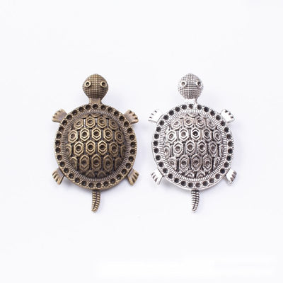 Group view of turtle silhouette with a patterned domed shell and top loop
