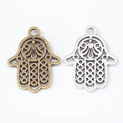 Product view of Hamsa hand charm showing an openwork Hamsa hand with lattice fingers and an ornamental center