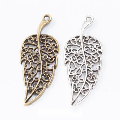 Grouped front views of the filigree leaf pendant charm in two antique metal finishes