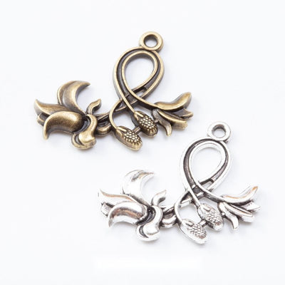 Flower charms with flared trumpet blooms and curling stems arranged together on a white background.