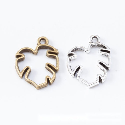 Front display of open monstera leaf bezel charm shown against a plain background.