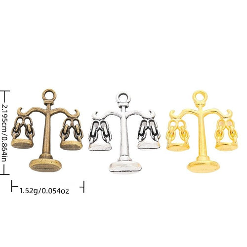 Overview of balance scale charm pieces on a white background