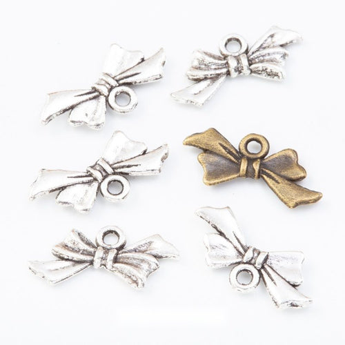 tied ribbon bow metal charms in two antique finishes shown together in the available finishes
