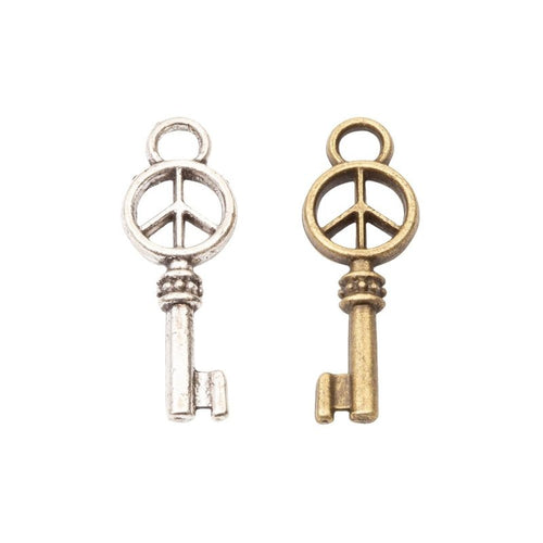 Assorted antique bronze and antique silver peace sign skeleton key charm pieces on white
