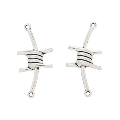 Front-facing arrangement of barbed wire connector charms on a white background