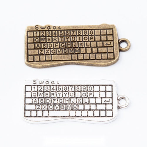 Rectangular computer keyboard charms with detailed raised keys arranged together on a white background.