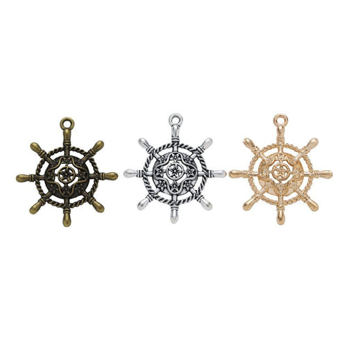 Assorted ship wheel charm pendants displayed together on a white background