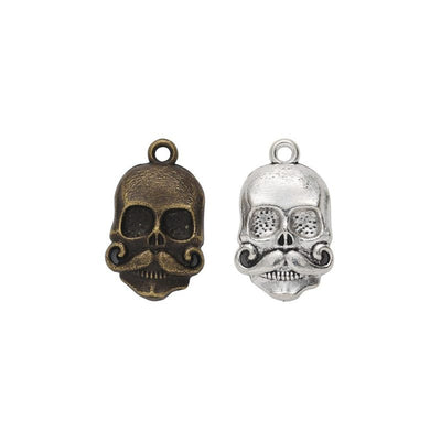 sculpted skull head metal charms in two antique finishes shown together in the available finishes