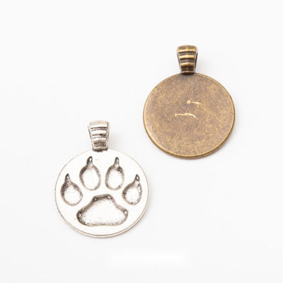 Paw Print Round Bezel metal pieces shown in the available finishes.