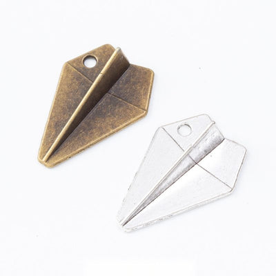 Folded Paper Airplane Charm Pendant finish comparison showing an angular folded form with a corner hanging hole