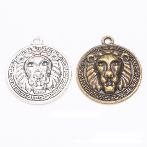 Assorted antique bronze and antique silver round lion head medallion charm pieces on white