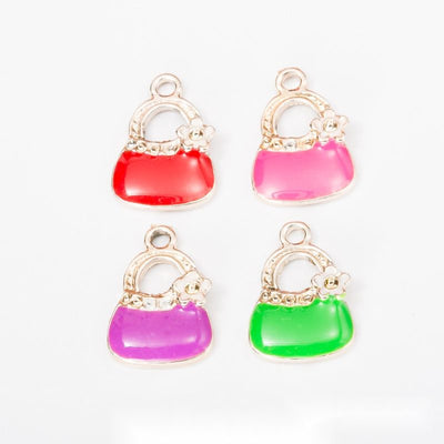 Product view of handbag charm showing a small handbag with a flower accent, bright enamel body, and gold-tone trim