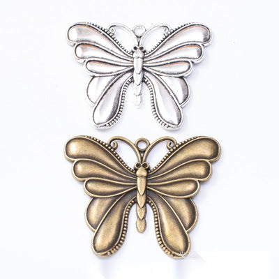 Layered Butterfly Charm Pendant finish comparison showing a solid upper butterfly layered over open lower wings