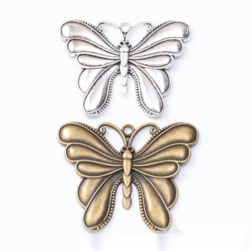 Layered Butterfly Charm Pendant finish comparison showing a solid upper butterfly layered over open lower wings