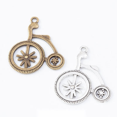 Product view of penny-farthing charm showing a vintage high-wheel bicycle with spoke details, a small rear wheel, and a 