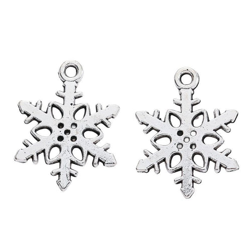 Front-facing arrangement of cutout snowflake charms on a white background