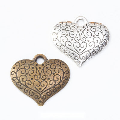 Overview of filigree heart charms in the available designs and finishes