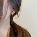 Gold Geometric Hoop Earrings with Sculpted Polished Metal Details view 4