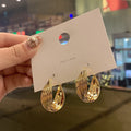Twisted Metal Hoop Earring Collection with Sculpted Polished Metal Details view 1
