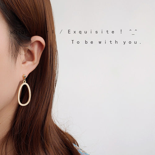 Gold open oval drop earring worn on ear in collage photo