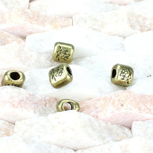Closer view of the square fortune character spacer bead surface and openwork details