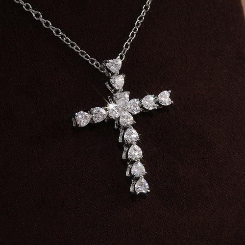 Cross pendant necklace front view on dark fabric background