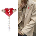 Hands Holding Broken Red Heart Brooch With Pearl Drop view 2