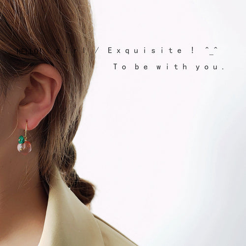 Model wearing pink peach fruit drop earring on lobe