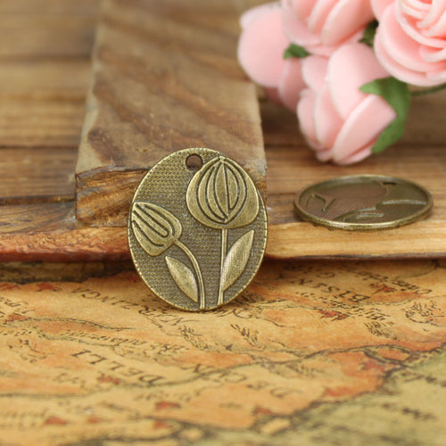 Oval Tulip Relief Metal Charm shown in grouped finish view