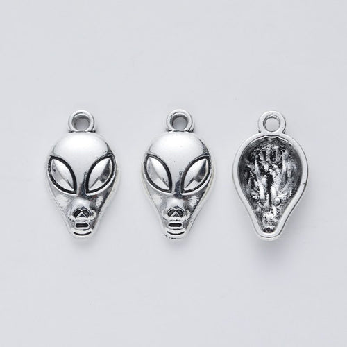 Close view of the relief and openwork details on the alien head metal charm