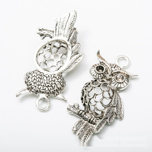 Close-up view of the openwork owl metal charm connectors showing its front and reverse metal details.