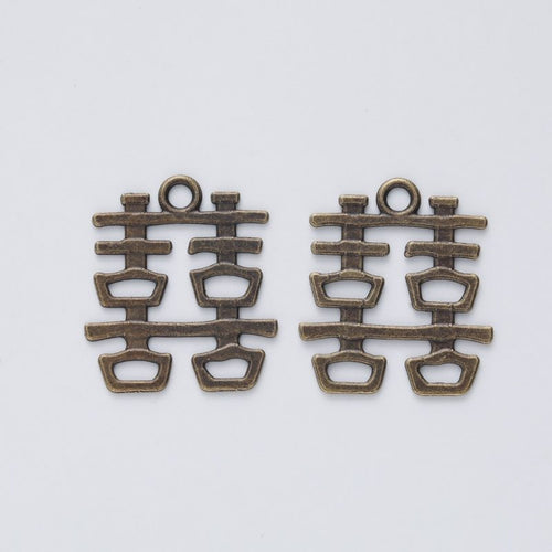 Front and reverse details of the double happiness symbol metal charm