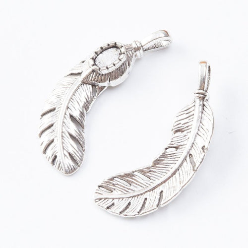 Close view showing the front and reverse details of the curved feather charm