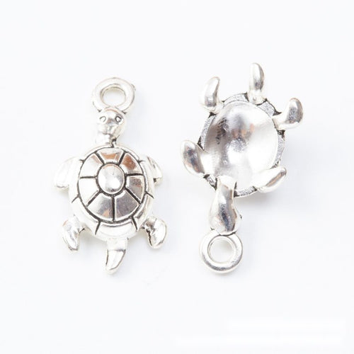 Close-up view of the raised shell turtle metal charms in two finishes showing its front and reverse metal details.