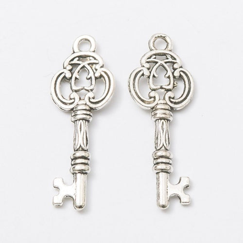 Front detail and finish comparison of the ornate quatrefoil skeleton key charm
