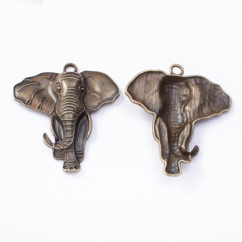 Front and reverse details of elephant head charms on a white background