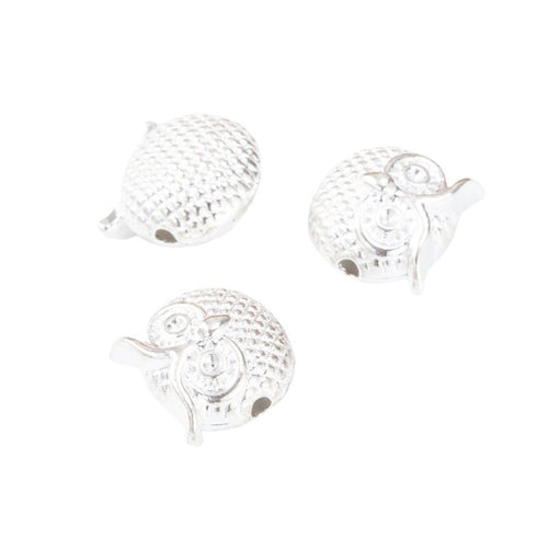 Close view of the owl spacer bead showing its raised front pattern