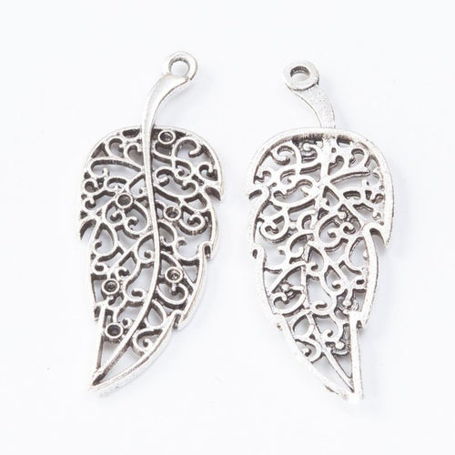 Close product view of the filigree leaf pendant charm in two antique metal finishes