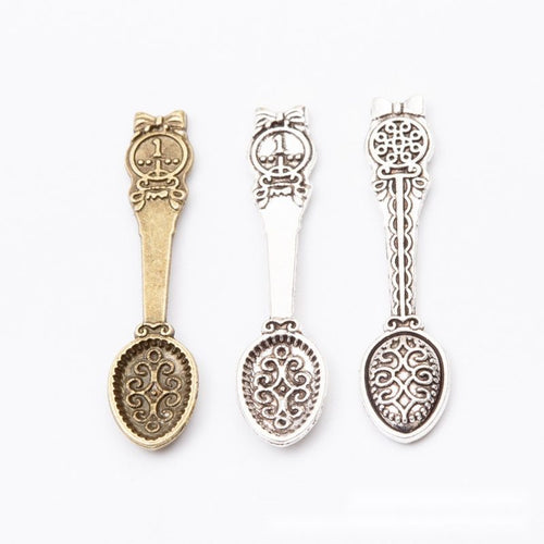 Close front view showing the shape and recessed details of the ornate spoon charms