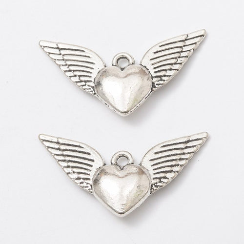 Close view of the a small heart flanked by long feathered wings