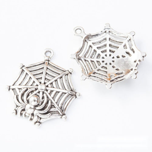 Close view showing the front and reverse details of the spider web charm
