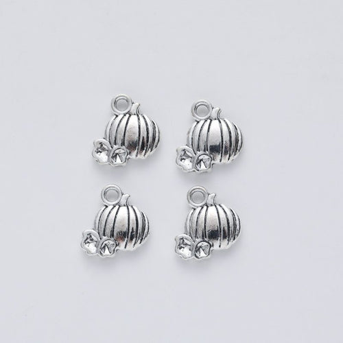 Close product view of the ribbed pumpkin and vine charm in three metallic finishes