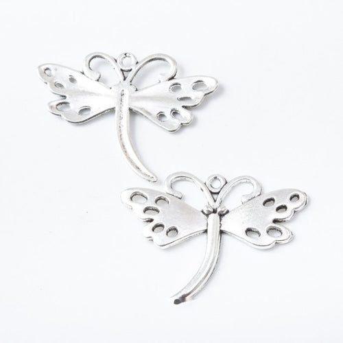 Closer view of the dragonfly silhouette with perforated wings and a curved tail