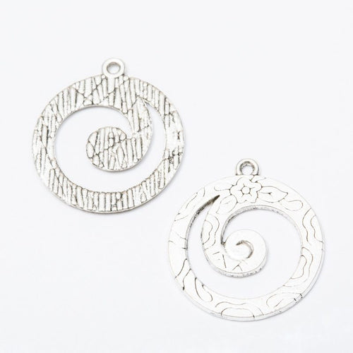 Front and reverse views of the spiral wave round metal charms in two antique finishes